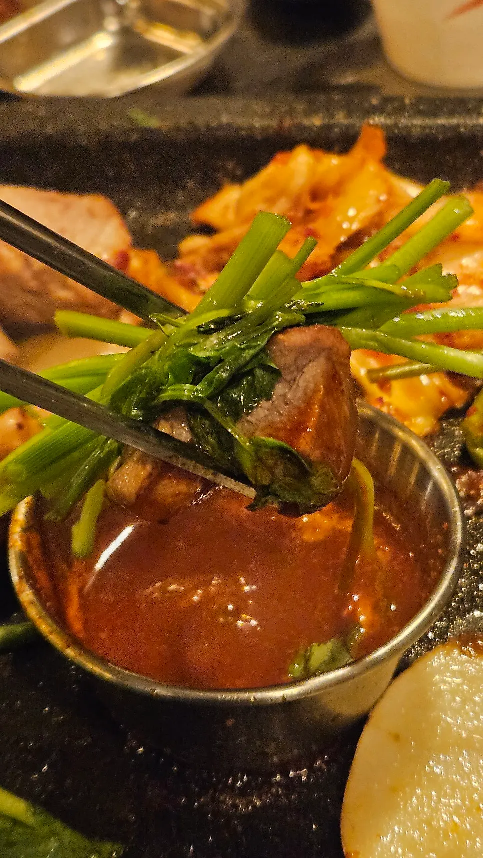 Close-up of a piece of meat topped with minari