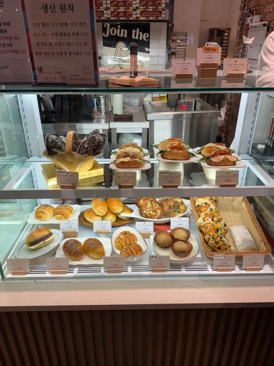 Boulangerie Tan breads arranged by type in a glass display case