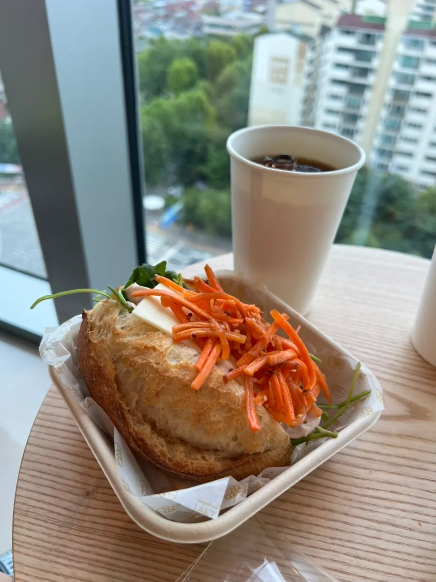 한 손으로 든 당근라페 치킨 샌드위치