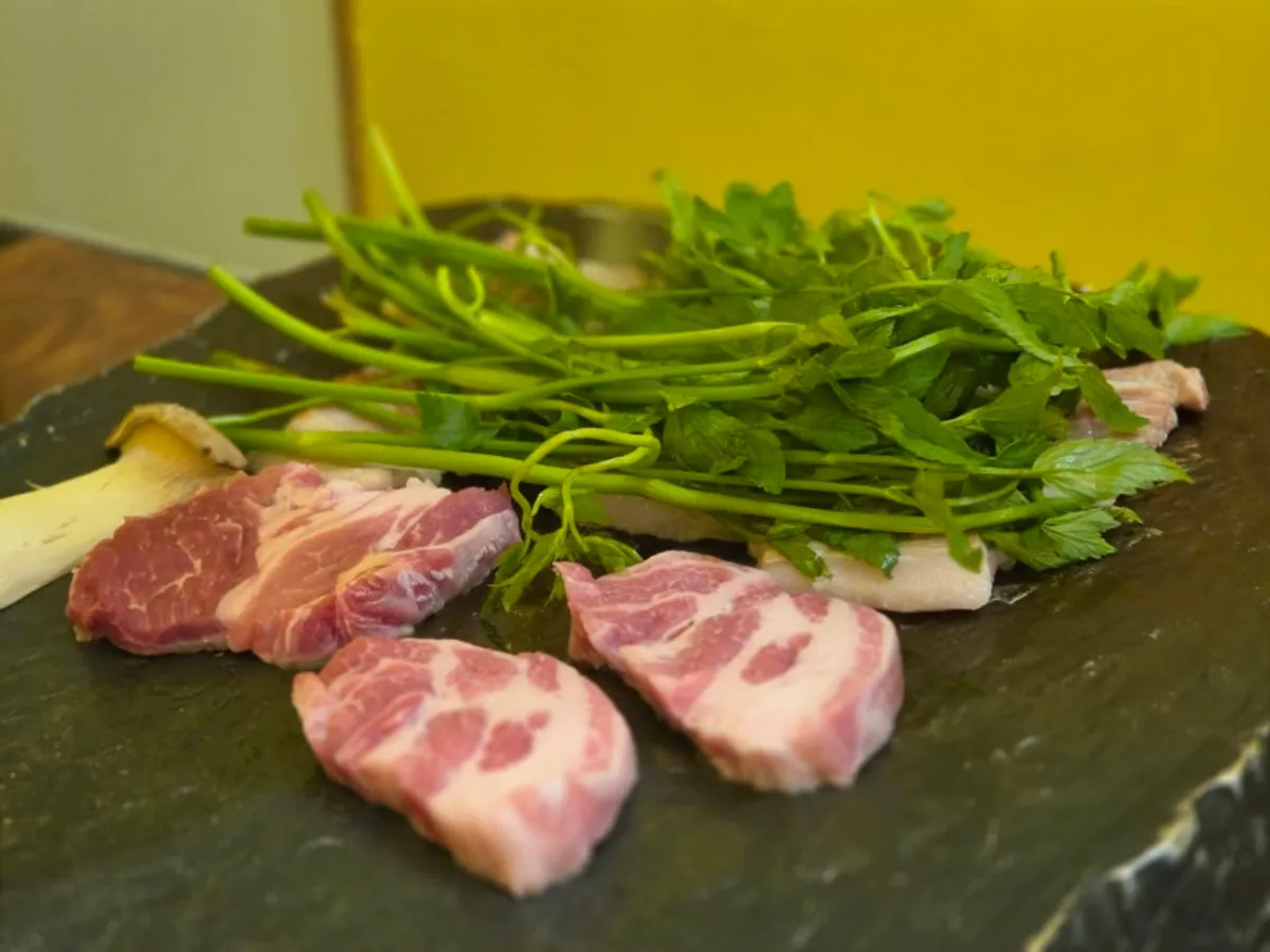 Pork belly and pork neck cooking on the cast-iron grill