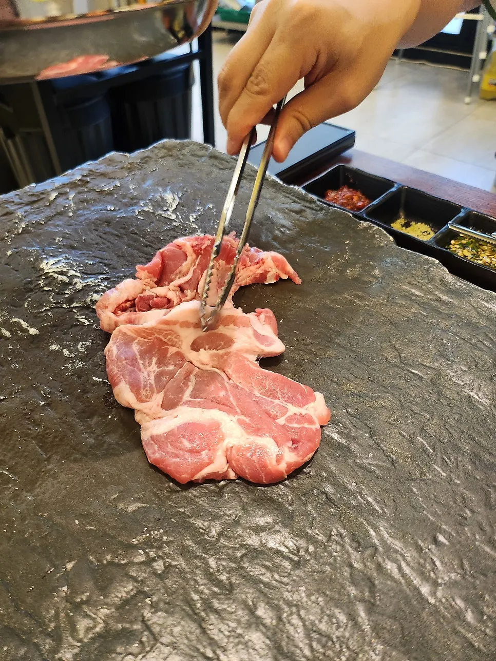 Meat on the cast-iron grill with onion and mushroom