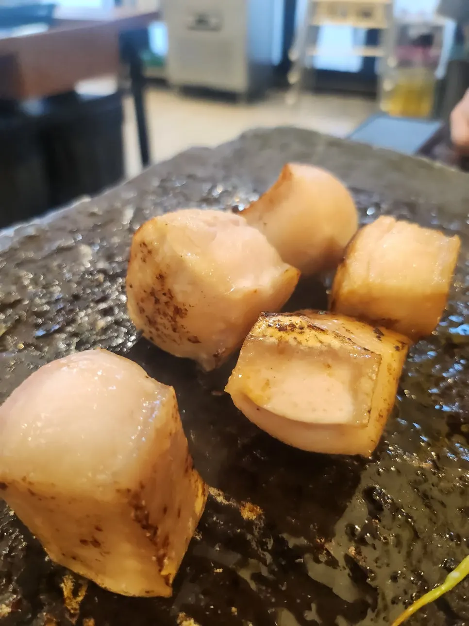 Kimchi and mushrooms cooking in fat at the bottom of the grill