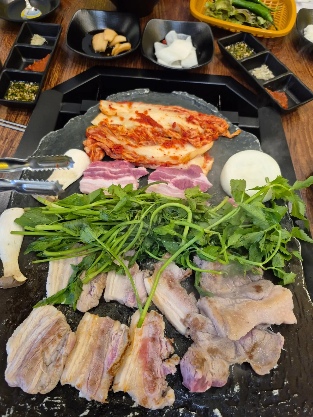 주물 불판에 미나리를 얹은 삼겹살 구이