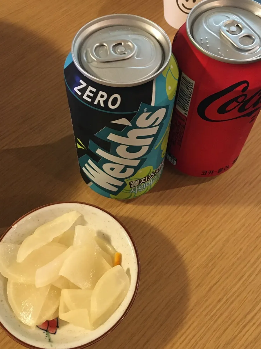 Pickled radish and two canned drinks served after ordering