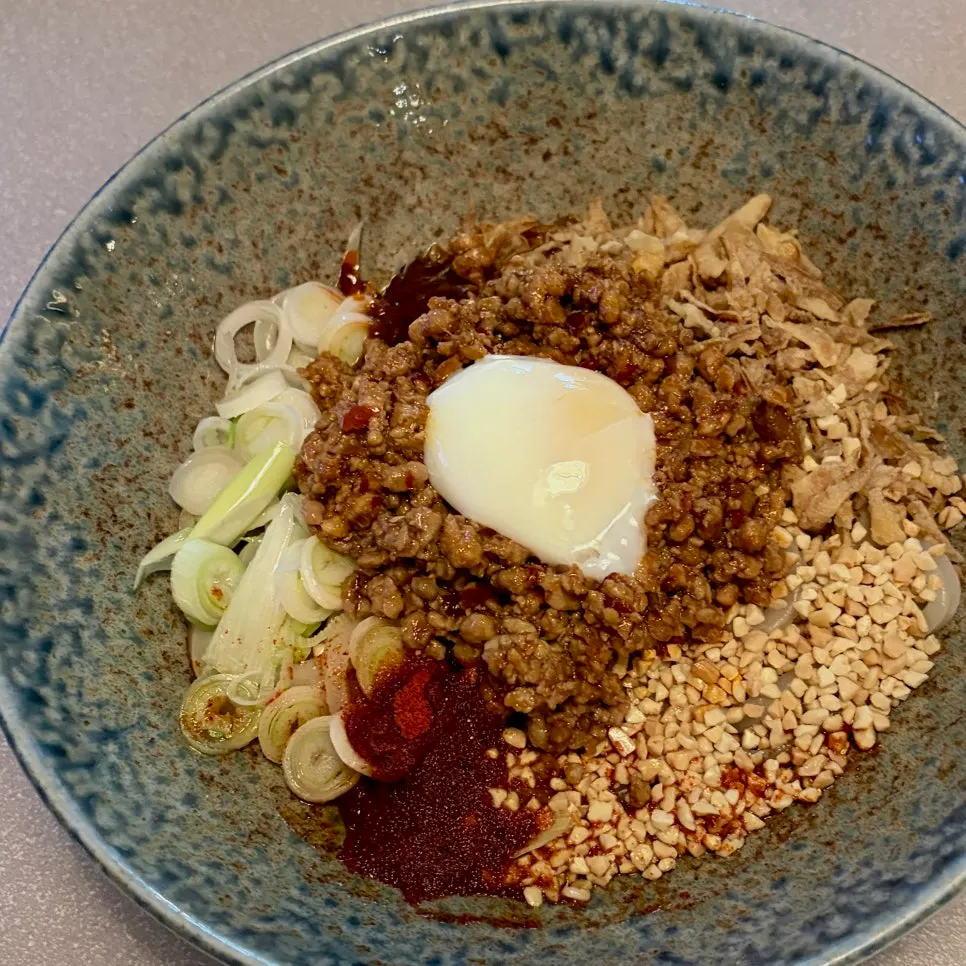 Mala yupodong topped with meat garnish and vegetables