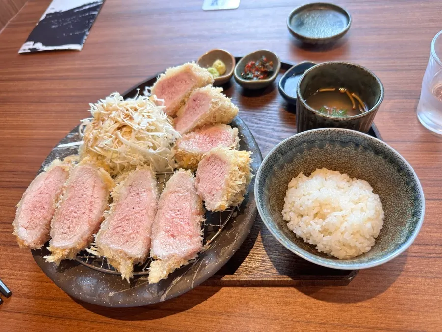 Trozo suave de ansim katsu sostenido con los palillos