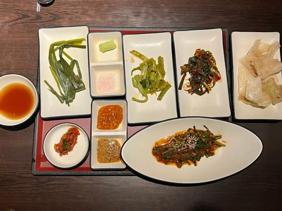 Side dish spread at Giun including gungchae namul and green onion kimchi