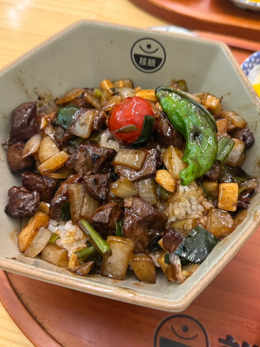Cube steak rice bowl topped with skirt steak and vegetables