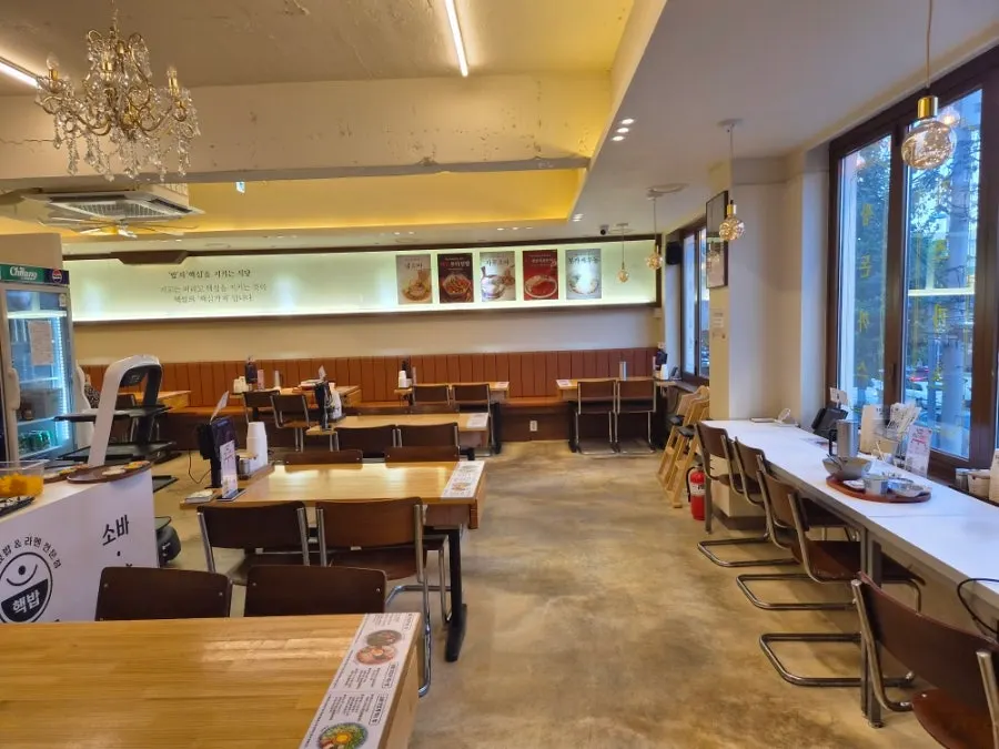 Wide dining hall with bright light from floor-to-ceiling windows