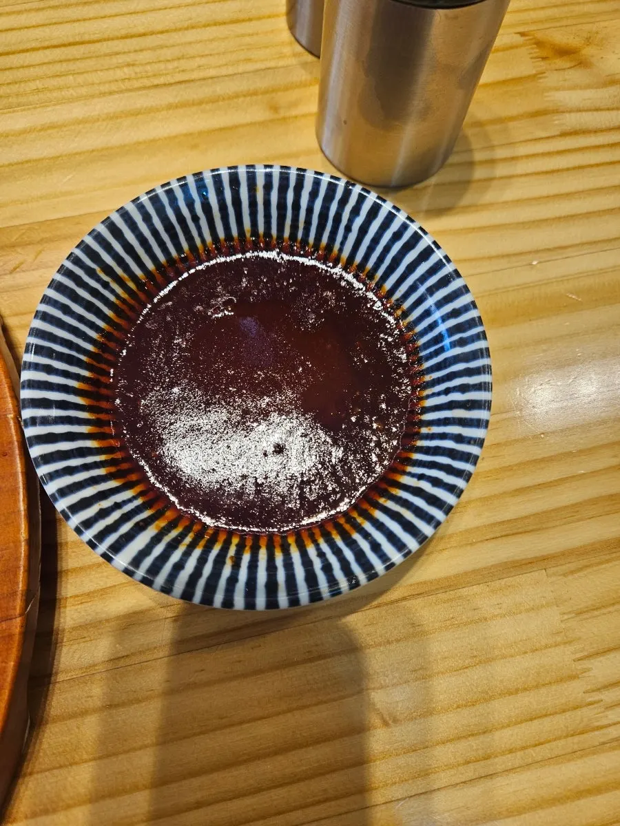 Close-up of spicy ramen topped with garnishes