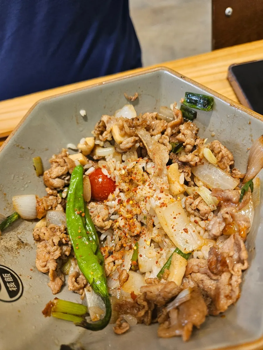 Meat-loaded rice bowl sprinkled with pepper and shichimi
