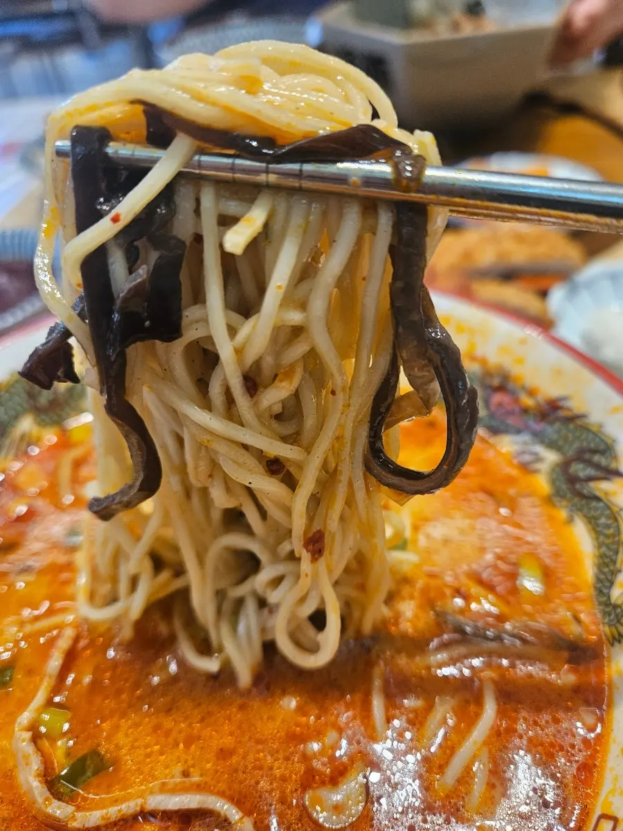 Noodles lifted up with chopsticks from the ramen
