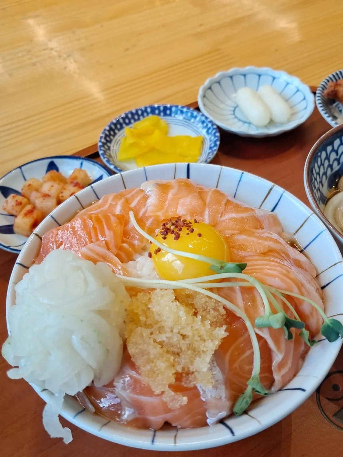 Close-up of salmon rice bowl topped with flying fish roe and egg yolk