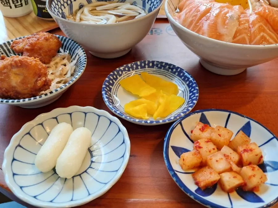 Two pieces of fried chicken and rice cake side dish served with the set
