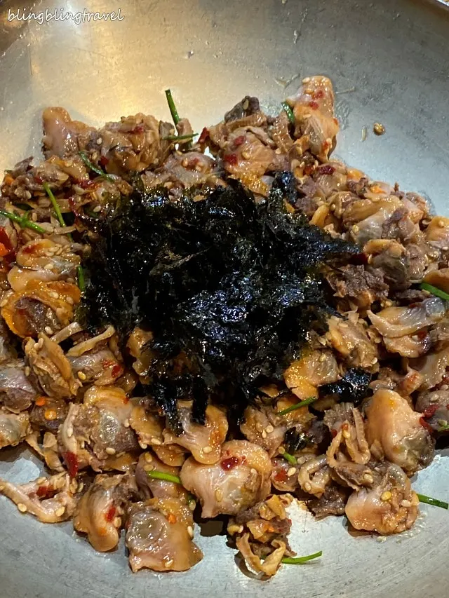 Cockle salad topped generously with seaweed flakes