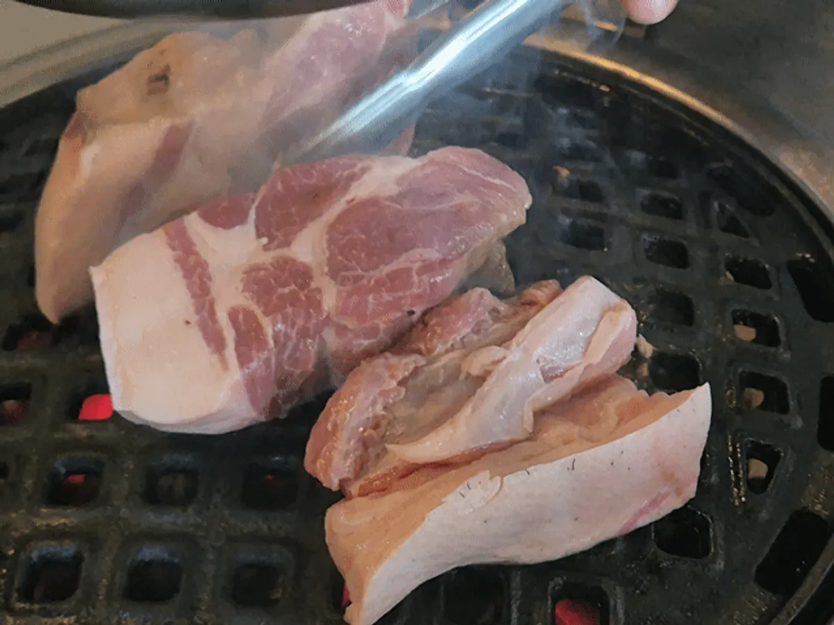 Black pork BBQ table setting at Kkamang Dwaeji Jungmun Branch