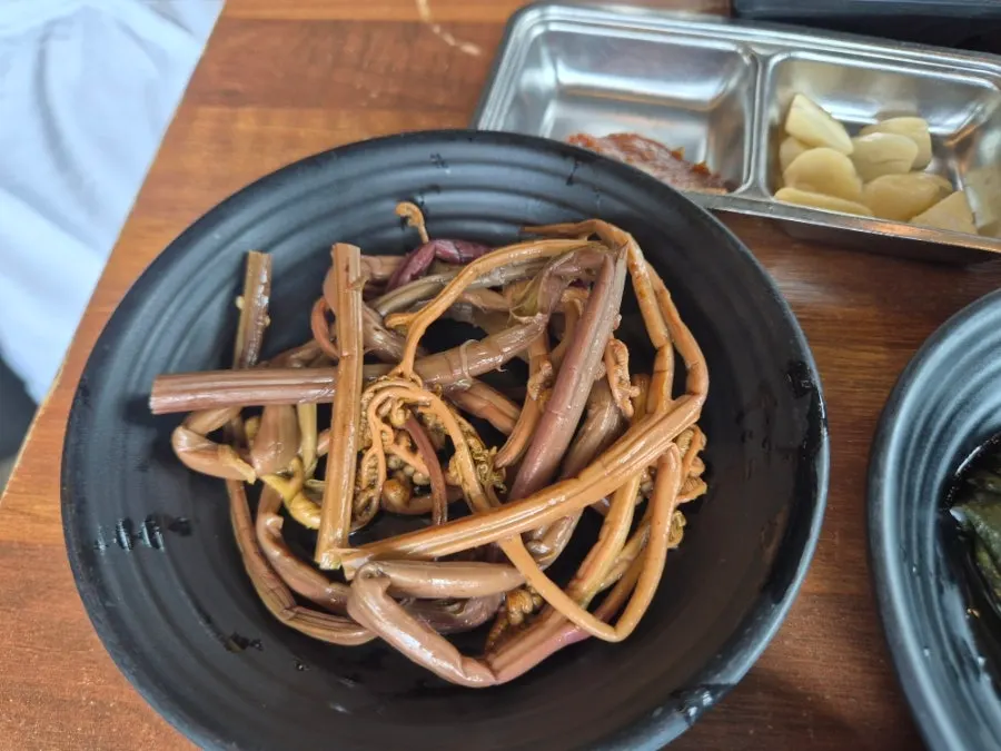Grilled black pork and side dishes spread