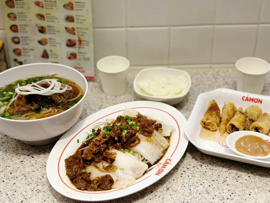 Table setting with pork backbone pho, bánh cuốn and chả giò