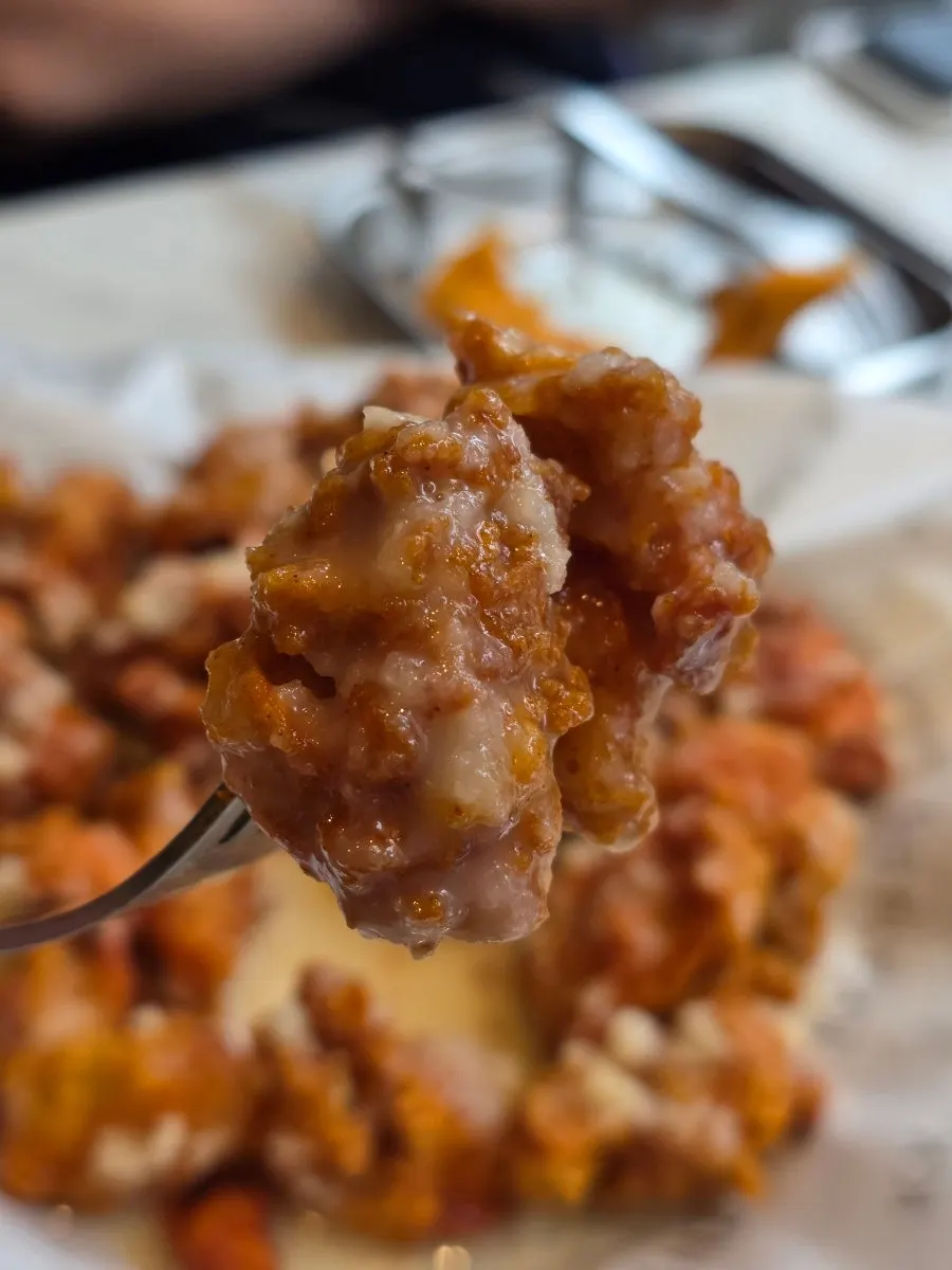 Garlic sauce pooled beneath the boneless chicken on the plate