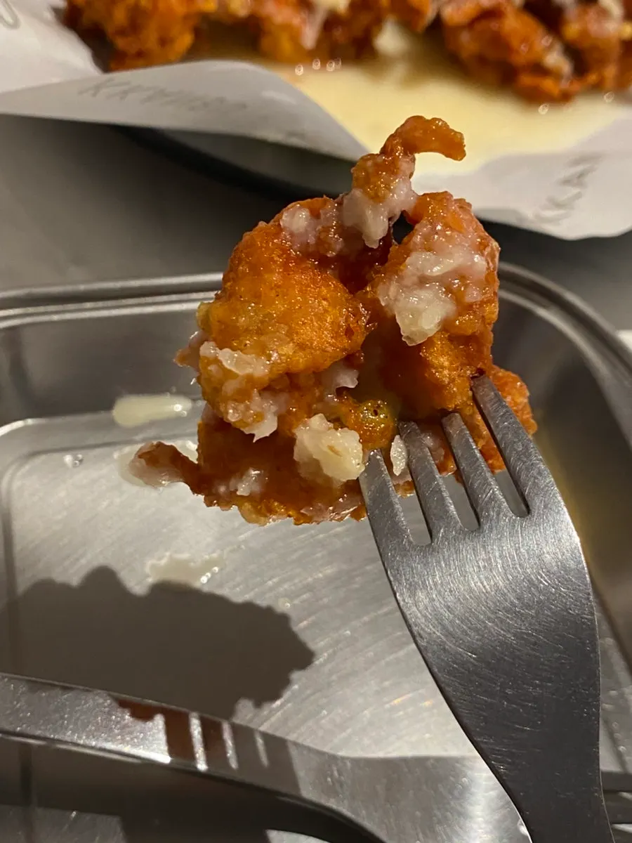 A piece of chicken coated in spicy, pungent garlic sauce