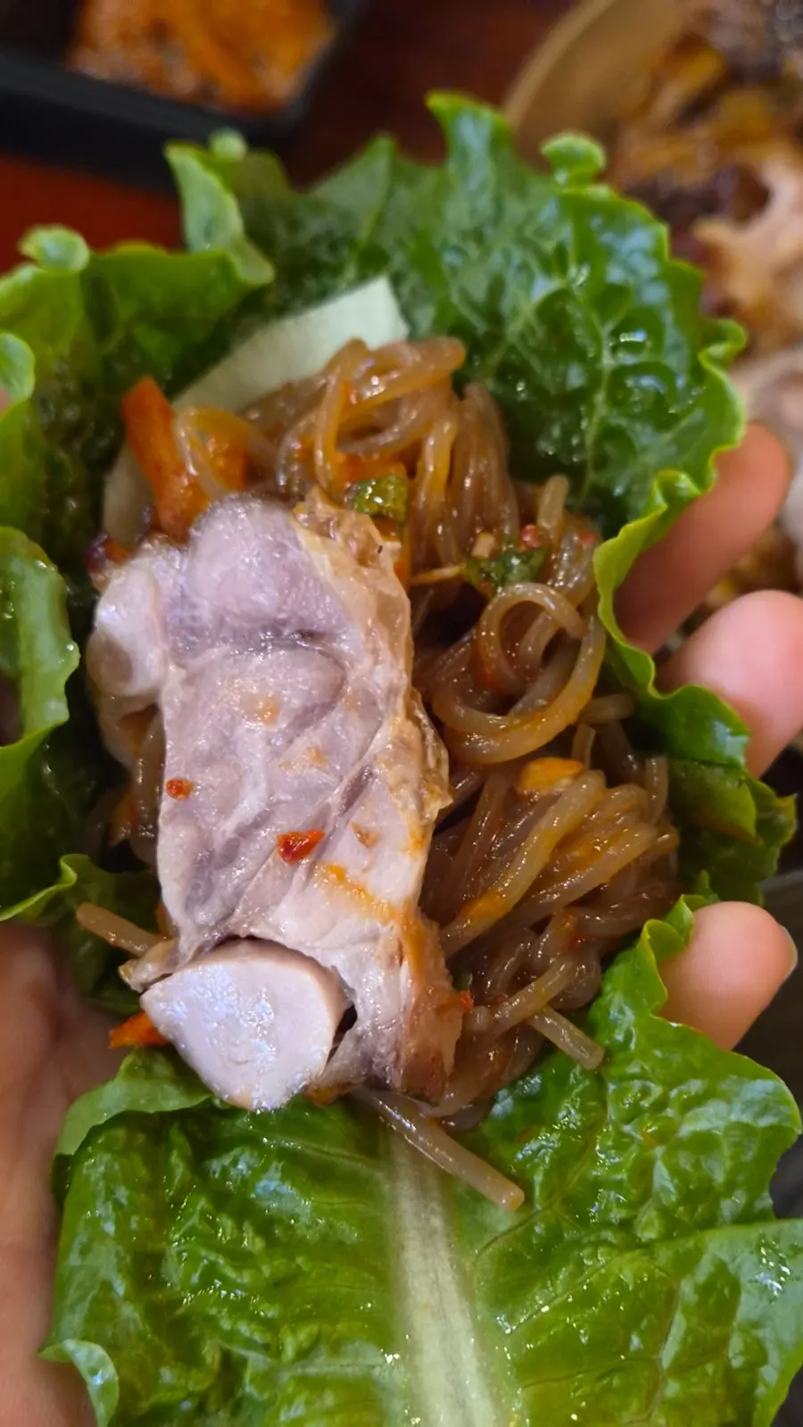 A bite of jjokbal topped with makguksu