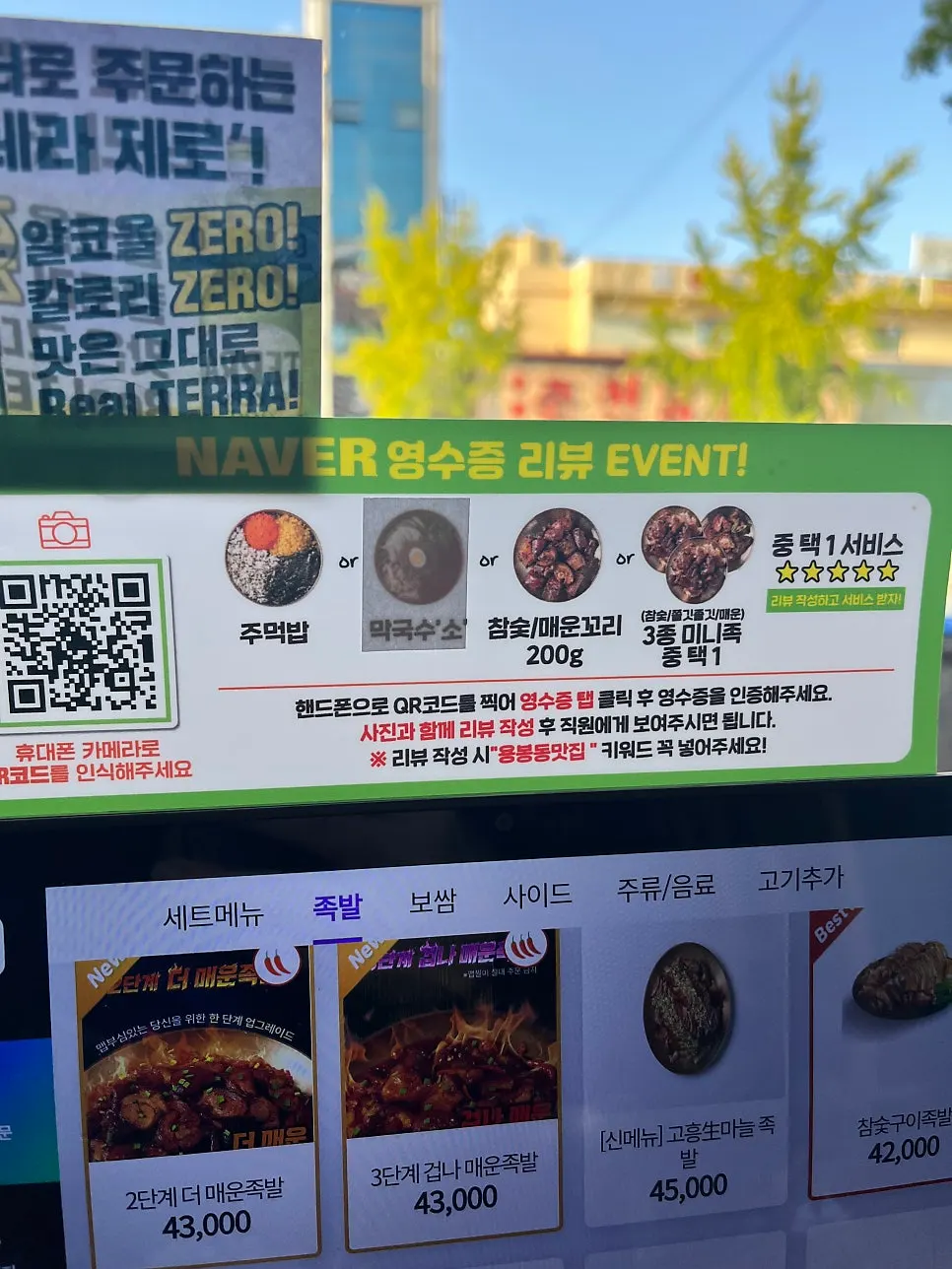 Sign listing charcoal-grilled jokbal and bossam menu items
