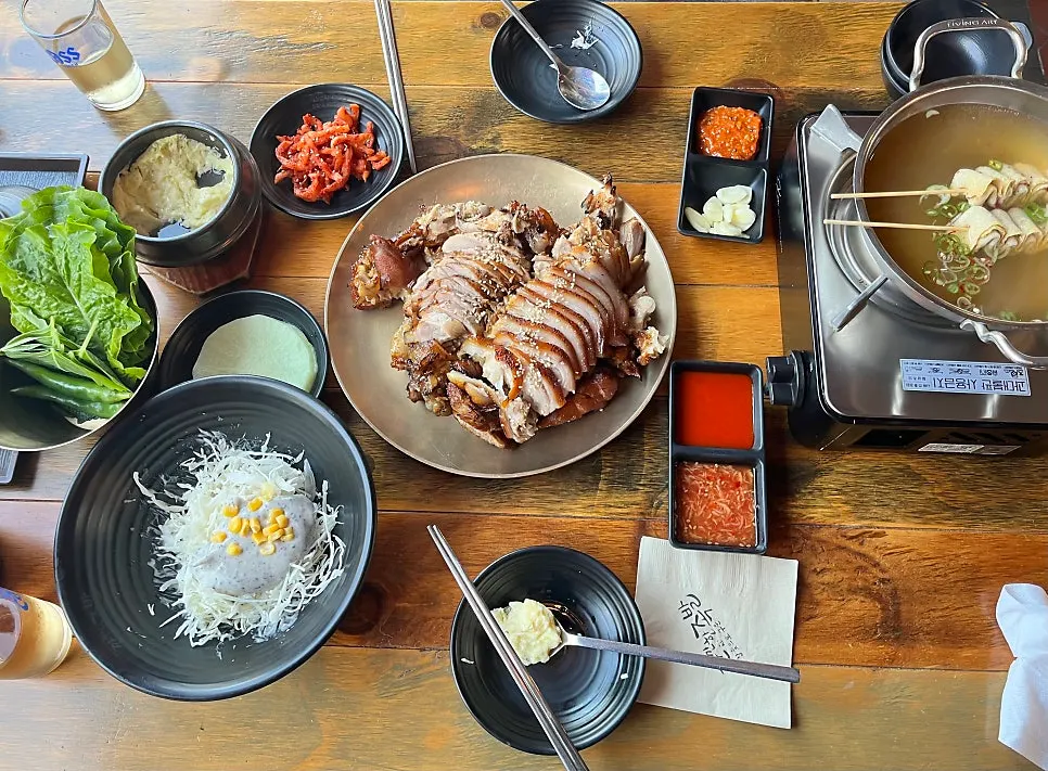 Medium charcoal-grilled jokbal with side dishes on the table
