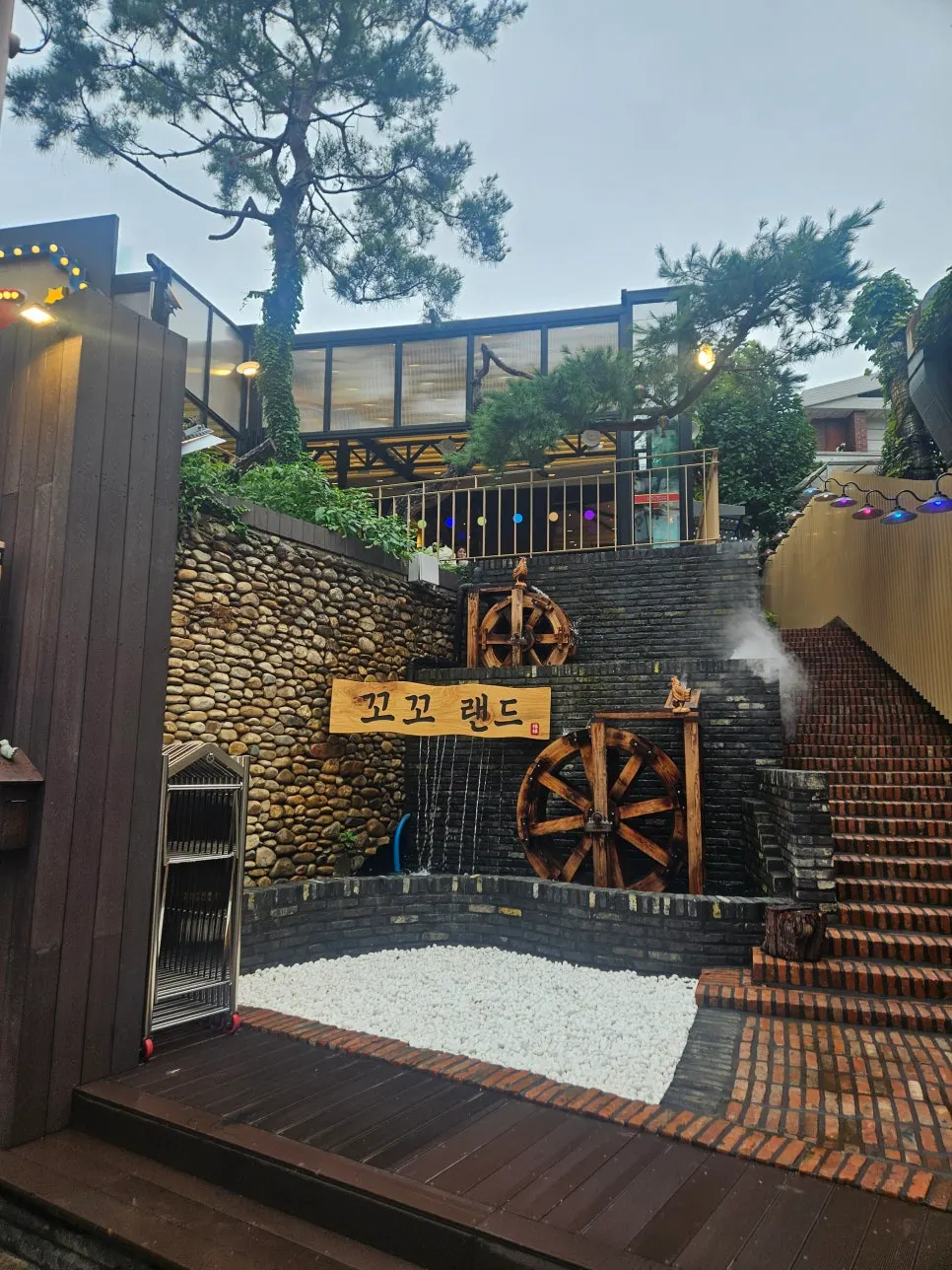 Kkoko Land entrance with waterwheel and wooden sign