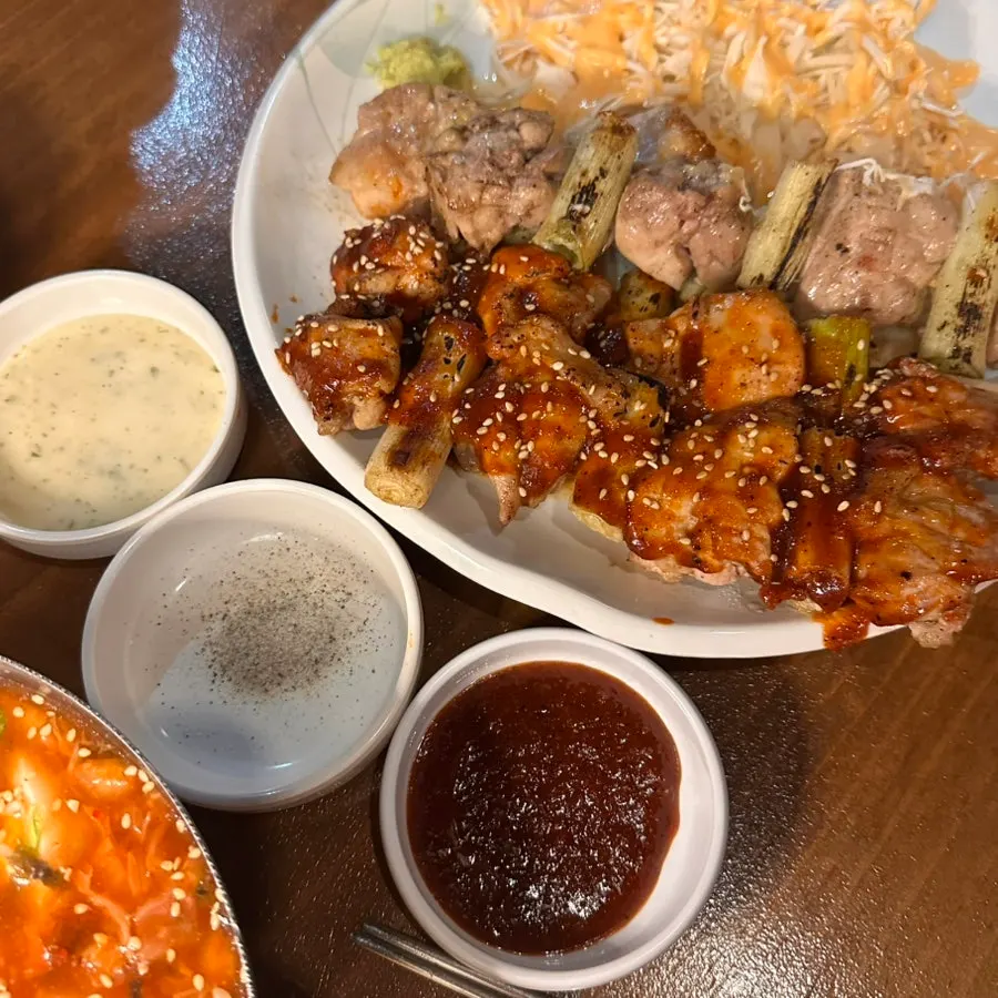 A bite of chicken and wasabi on grilled green onion