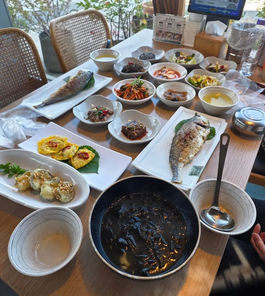 Two dried corvina and the 12-dish side spread on the table
