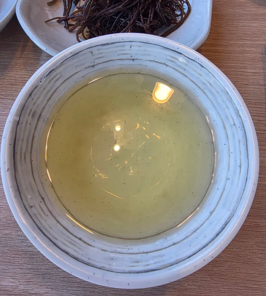 Green tea water served alongside the dried corvina