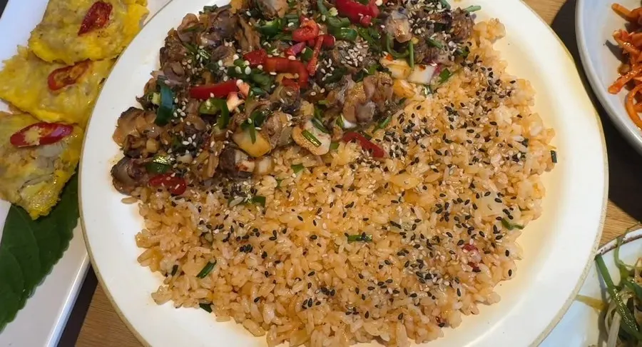 Cockle bibimbap topped with chives and seaweed flakes