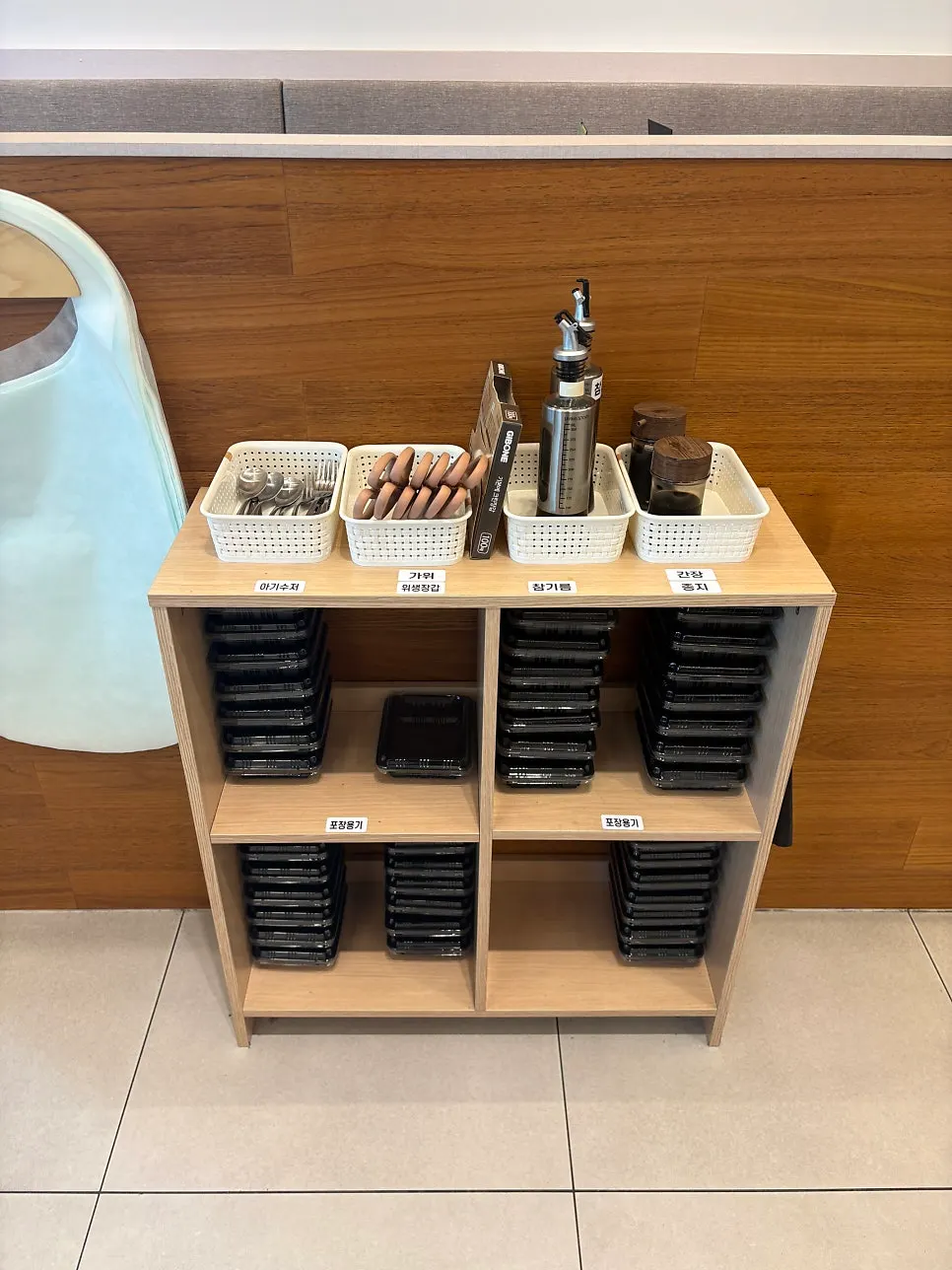 Self-serve to-go containers and utensils set up near seating
