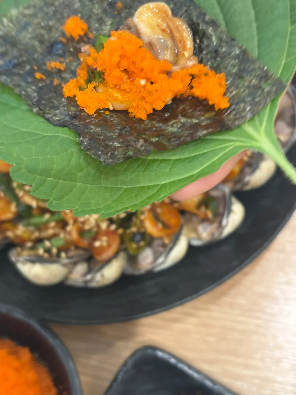 Cockle bibimbap loaded on a spoon