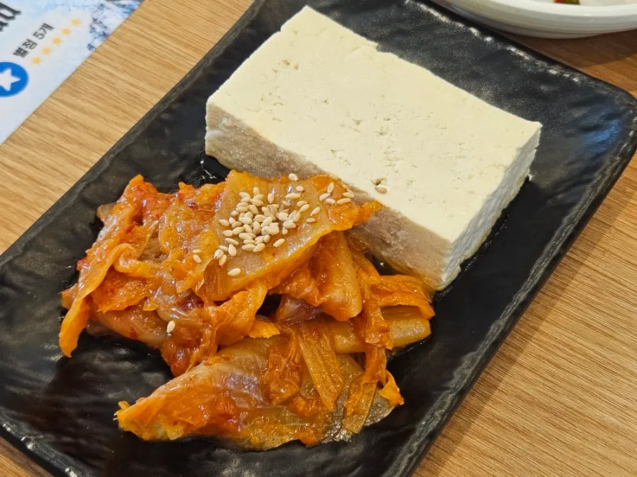 Side dishes including cucumber seaweed salad and tofu kimchi