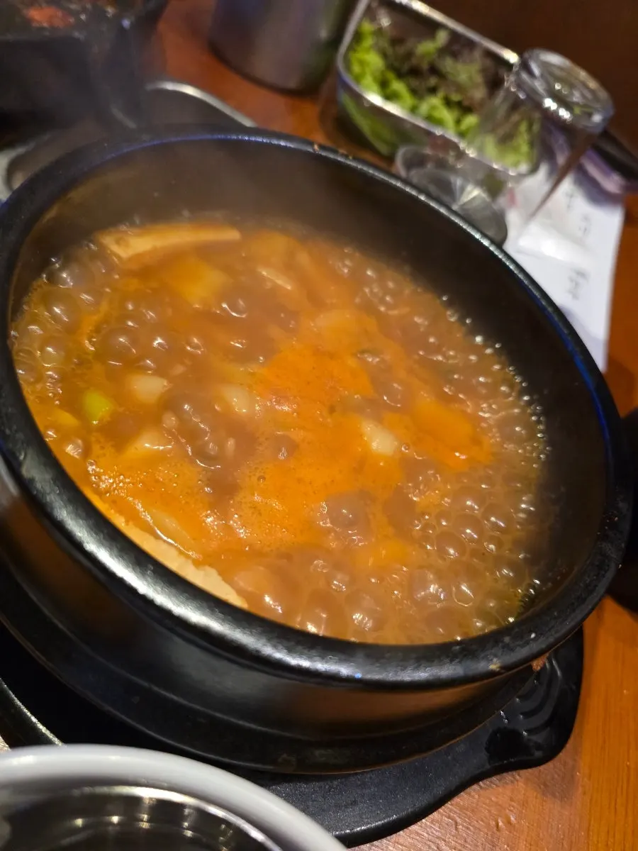 쌈과 김치에 곁들인 삼겹살 한 점