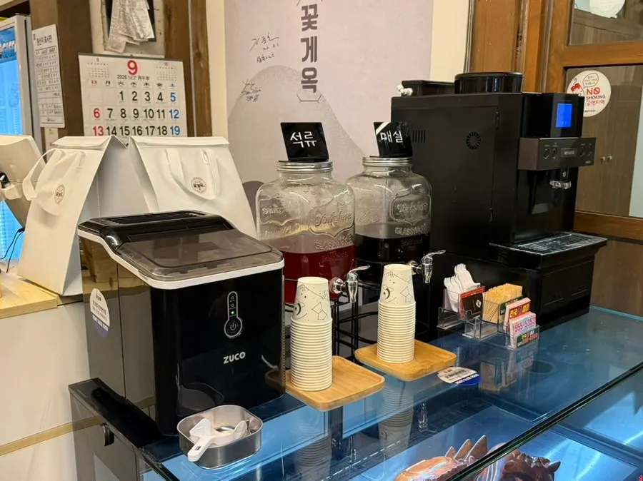 카운터 옆 석류 음료와 매실차, 원두커피 머신