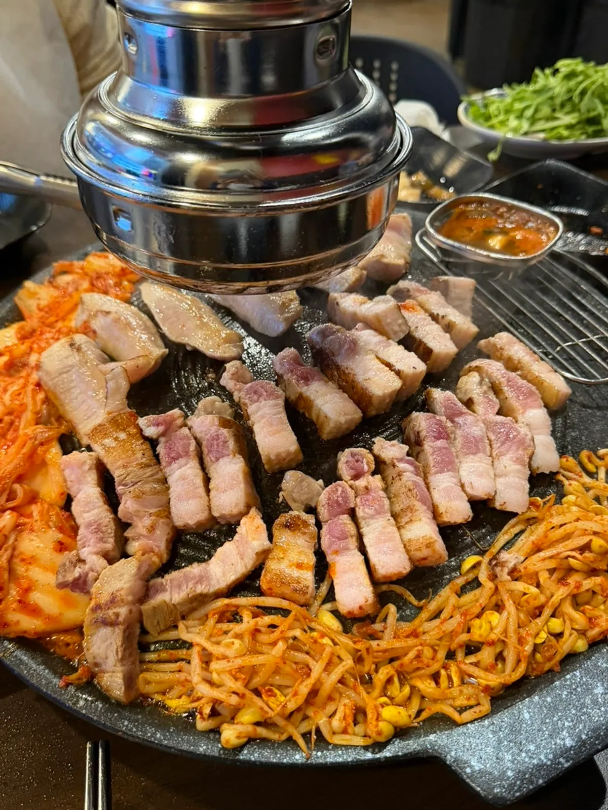Thick duroc pork belly grilling on the cauldron lid