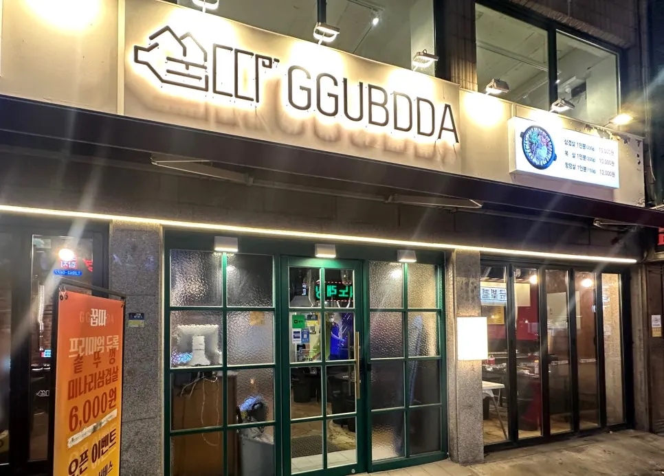 초록색 문과 간판이 있는 꿉따 매장 입구
