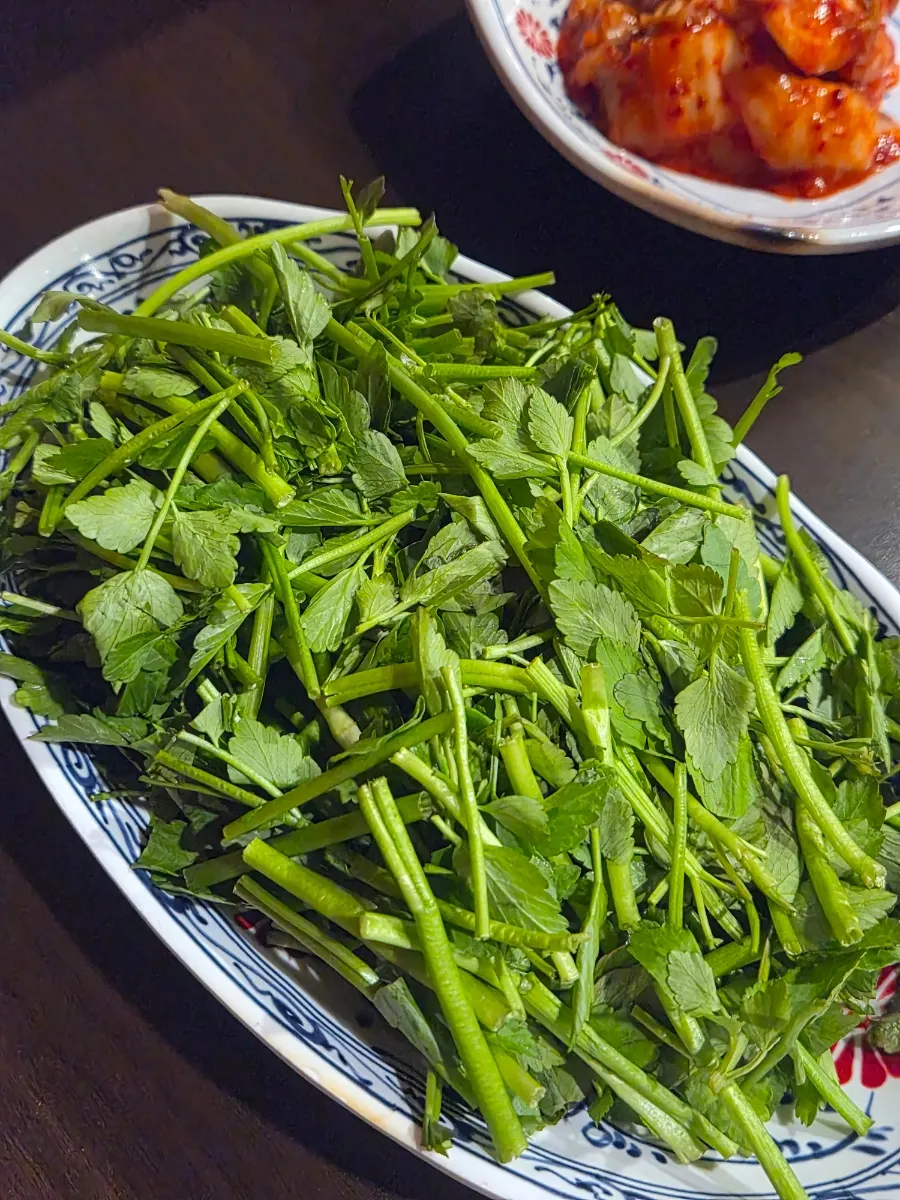 Cauldron-lid grill with minari, kimchi, and bean sprouts