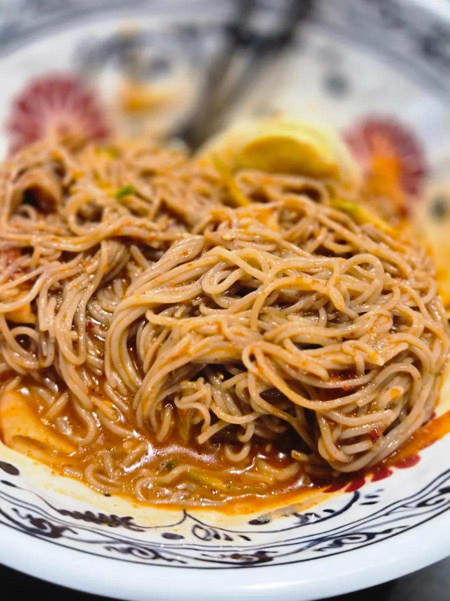 Noodles served alongside the grilled meat spread
