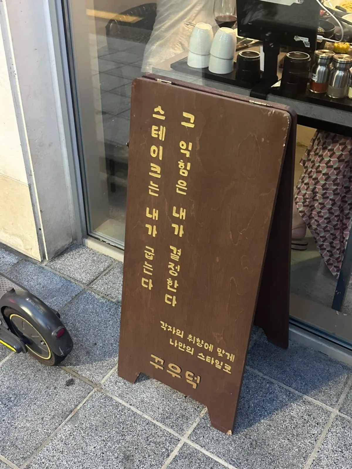 Kkuudeok's wooden sign in a cute font