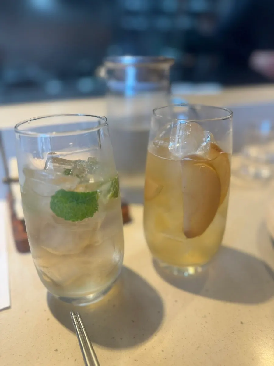 Two glasses, a non-alcoholic mojito and a kombucha