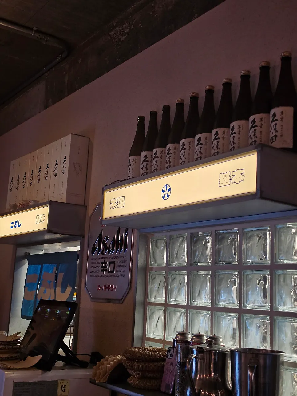 Space in front of the kitchen lined with sake bottles
