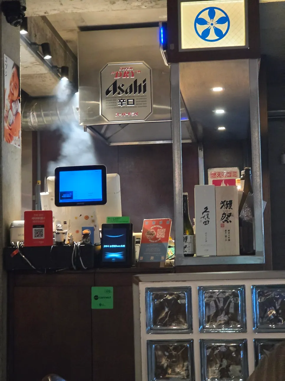 Bar seating with an Asahi sign hanging above