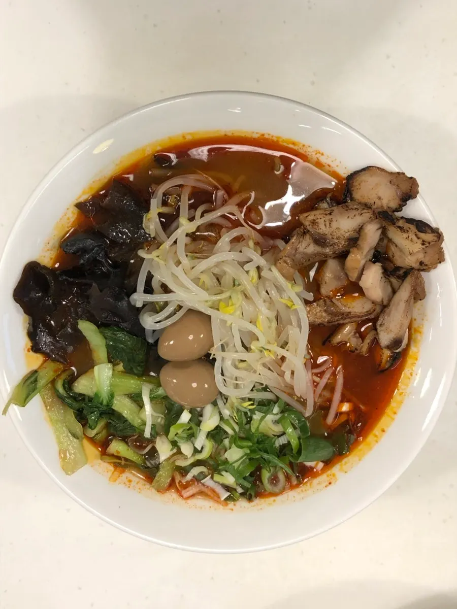 Chicken char siu mala ramen topped with bean sprouts and quail eggs