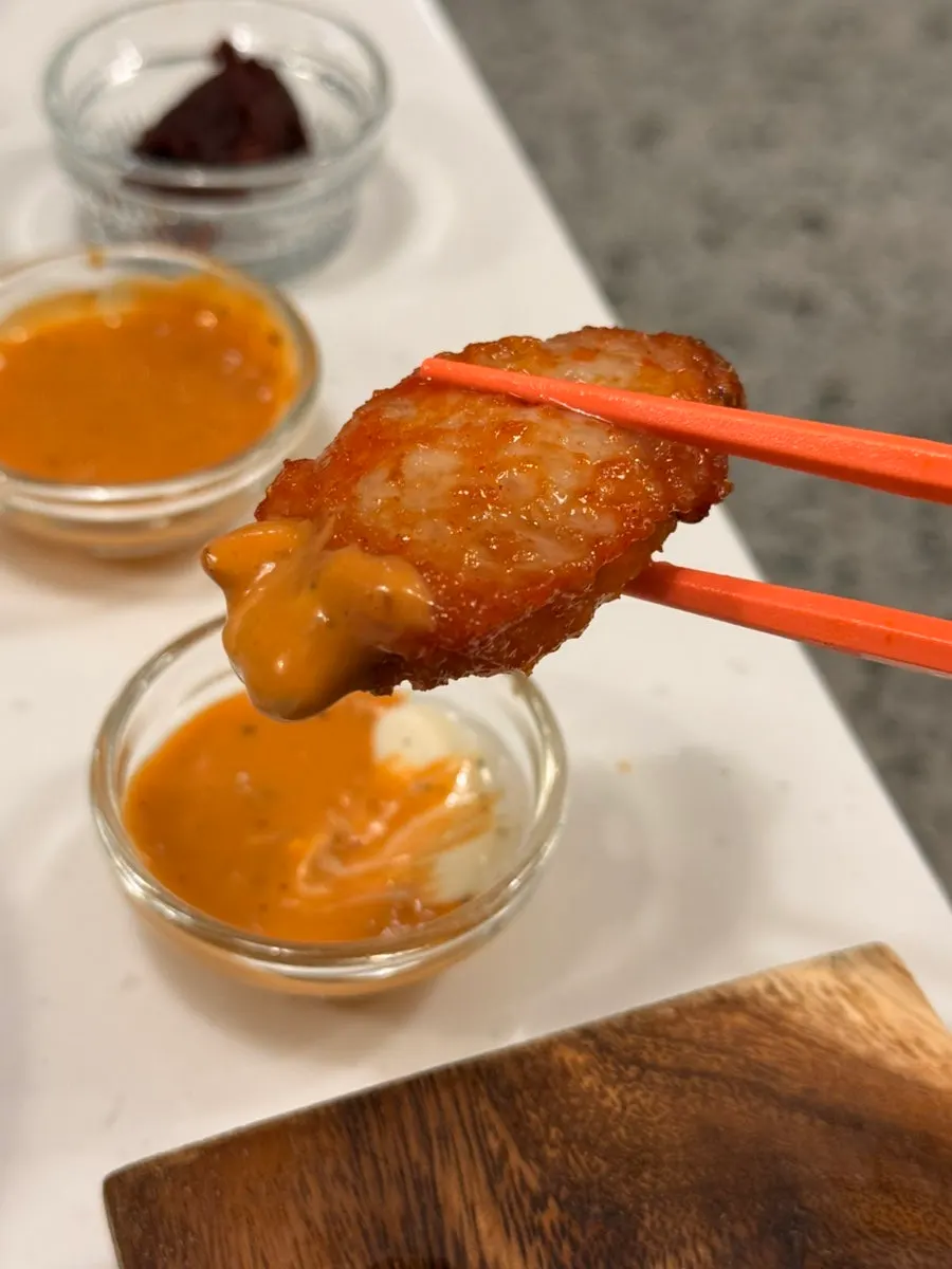 Fried chicken wing dipped in sauce