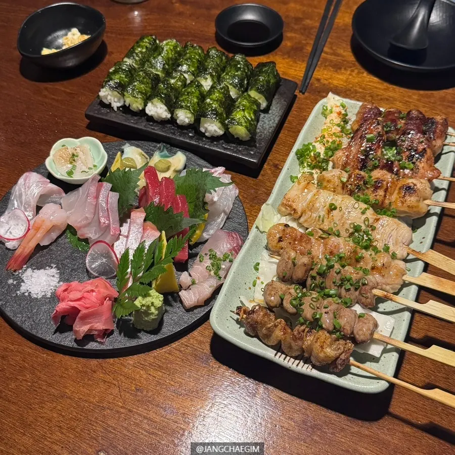 A full spread of sashimi, yakitori, and salt gimbap