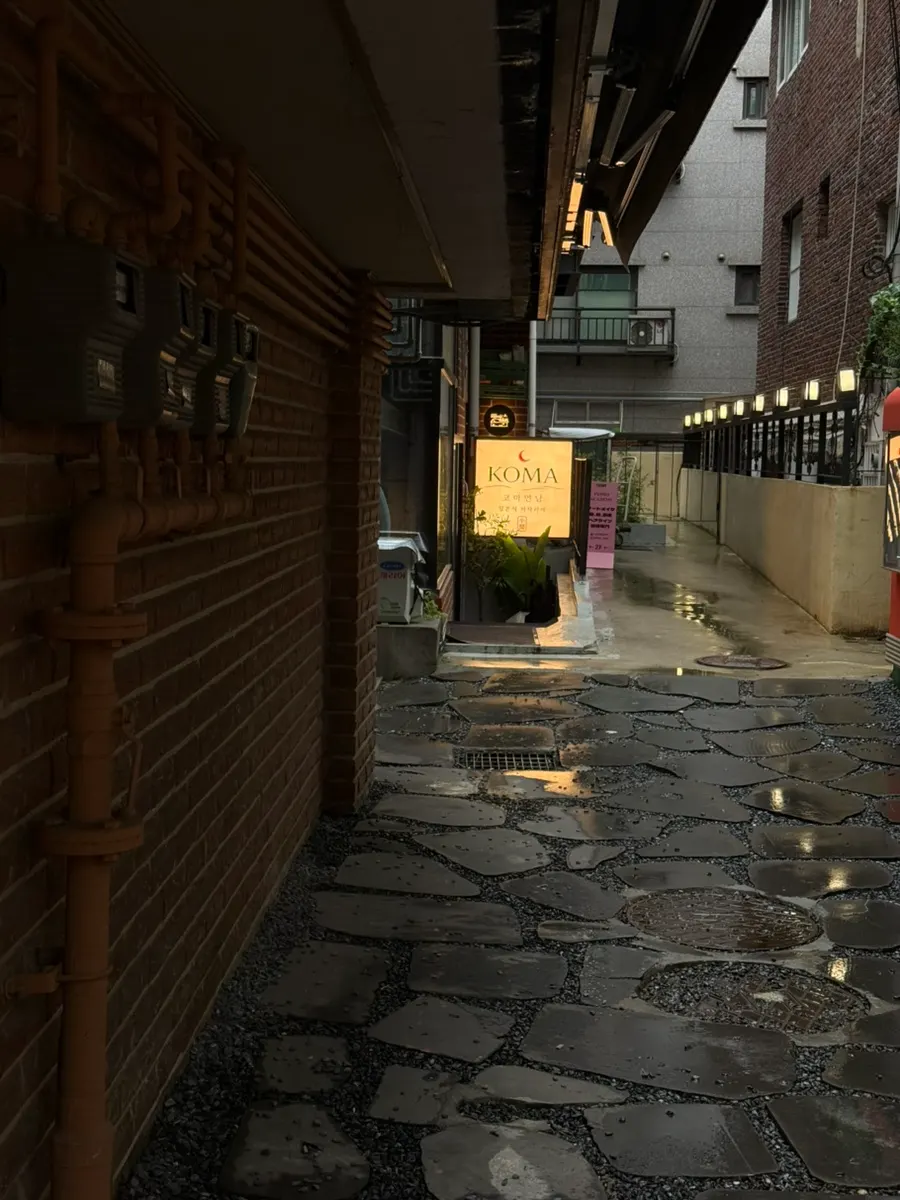 Standing sign in front of the alley leading to Koma Yeonnam