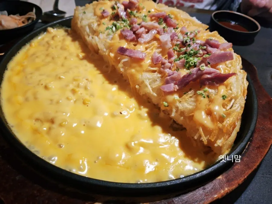 Cheese being added to the bubbly cheese potato pancake as it cooks